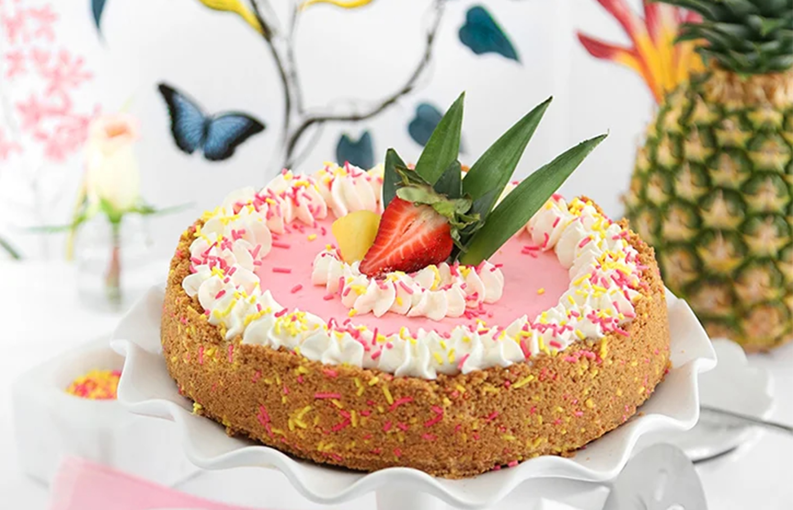 pink pie with a strawberry on top placed on a plate